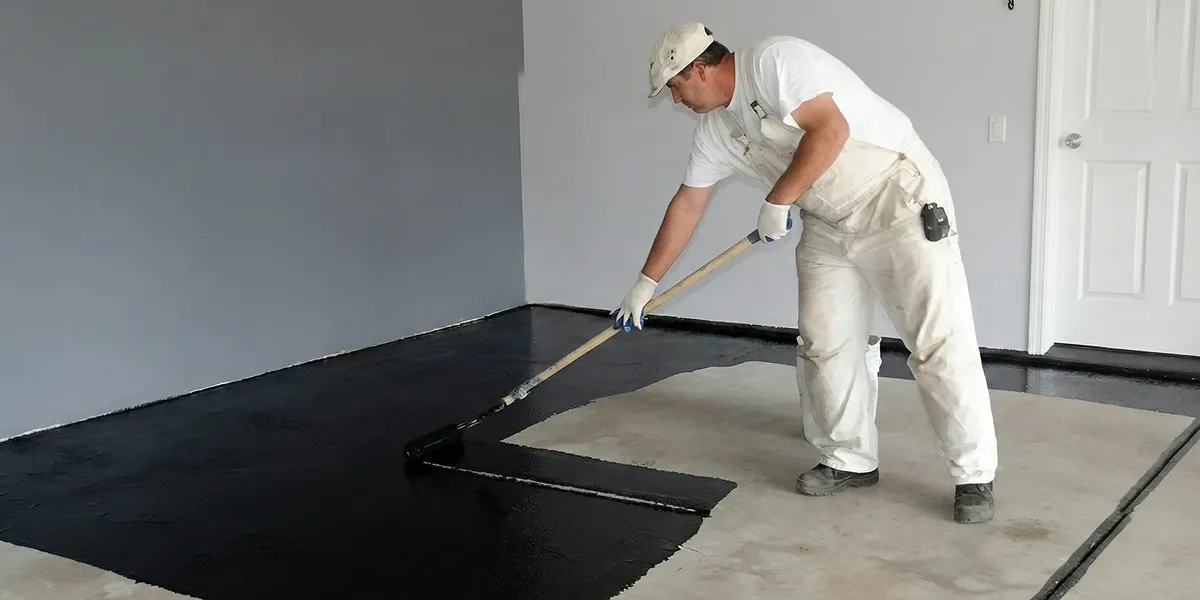 basement waterproofing professional applying waterproof coating to protect a basement floor in Charleston, SC